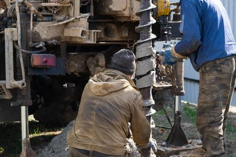 Team of workers with drilling rig on car are drilling artesian well for wat.. Stock Photos