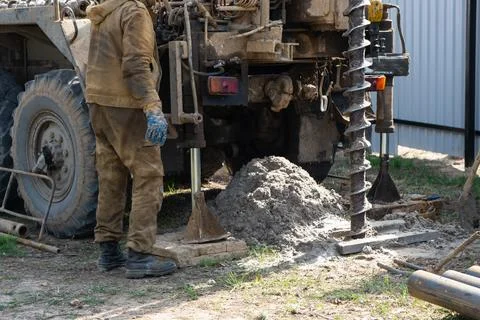 Team of workers with drilling rig on car are drilling artesian well for wat.. Stock Photos