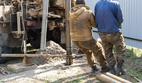 Team of workers with drilling rig on car are drilling artesian well for wat.. Stock Photos