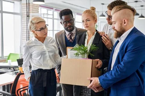Team of workers support their female colleague leaving work Stock Photos
