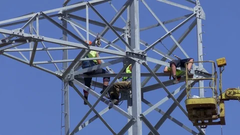 Team of Workers in Uniform Wearing Time at Top of Electric Tower Against Stock Footage 96129843