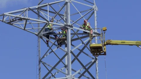 Team of Workers in Uniform Wearing Time at Top of Electric Tower Against Stock Footage 96371888