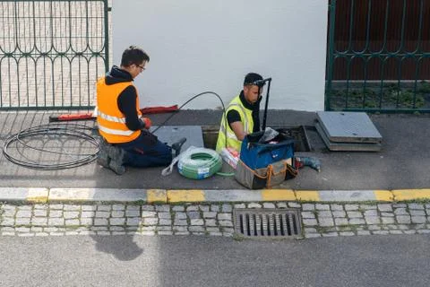 Team of workers working on implementation of fiber optic cables in sewage s.. Stock Photos