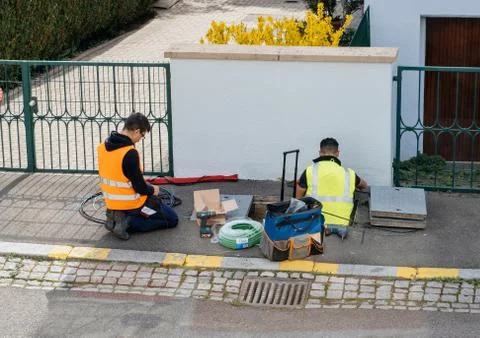 Team of workers working on implementation of fiber optic cables in sewage s.. Stock Photos