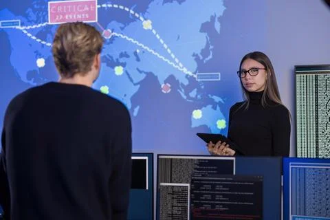 Team working in a cybersecurity operations center with digital monitoring tools 写真素材