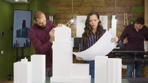 Team of young architect checking last details on corporate building model Stock Footage 117187052