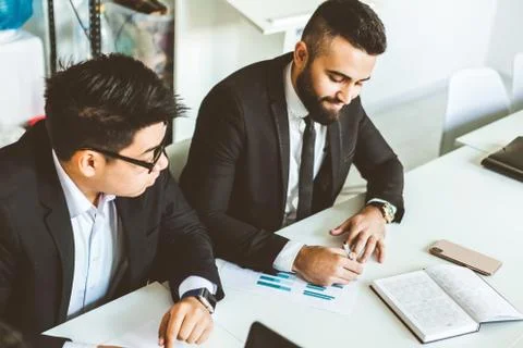 A team of young businessmen working and communicating together in an office Stock Photos