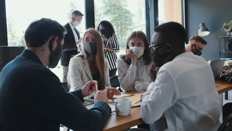 Team of young creative happy business people wear masks working at office table Video stock 137205853