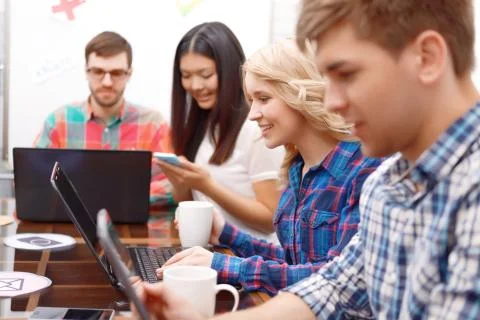 Team of young developers sitting at the table Stock Photos