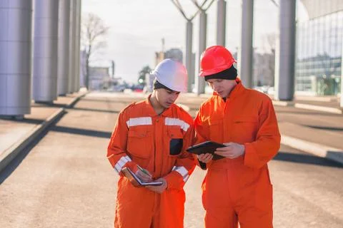 Team of  young engineers discussing project and writing in the note book. Foto stock