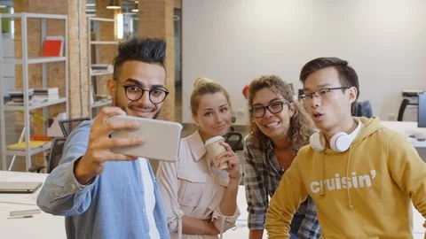 Team of Young Joyous Colleagues Taking Selfie with Smartphone in Office Vidéo 126140942