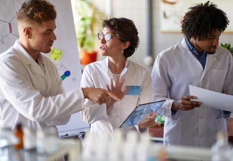 Team of young laboratory technicians discussing test results Stock Photos