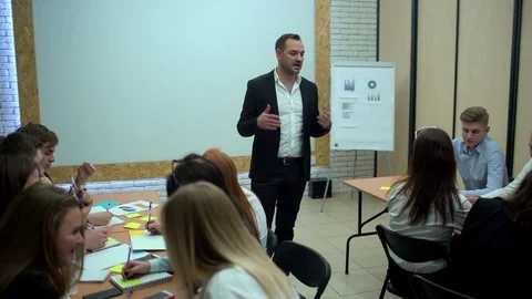 Team of young managers is sitting together at the table and listening training Stock Footage 85039539