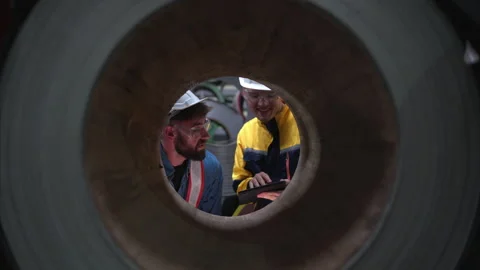 A team of young men working in a warehouse storing rolls of metal sheets Stock Footage 254760037