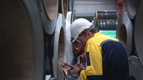 A team of young men working in a warehouse storing rolls of metal sheets Stock Footage 254765895