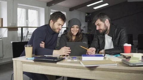 Team of young professionals having a meeting in a creative office. Looking at Stock Footage