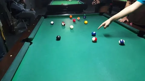 Teammates players discuss to select the correct ball then sinking yellow ball Stock Footage 58952476