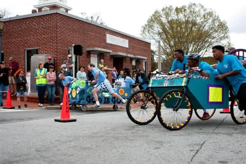 Teams push beds around corner in unique race fundraiser Stock Photos