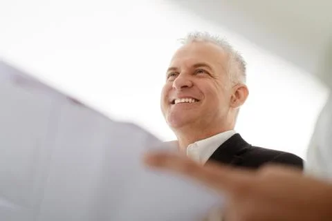 Teamwork With Architect Looking At Plans During Meeting Stock Photos