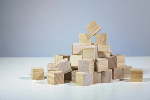 Teamwork with a broad base is the way up, heap of wooden cubes holding one of Stock Photos