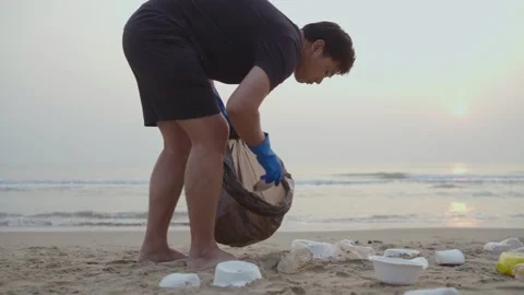 Teamwork cleaning plastic on the beach. Volunteers collect trash in a trash bag. Stock Footage 237944744