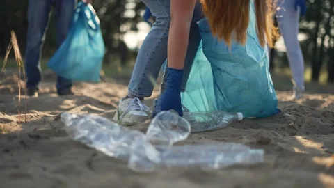 Teamwork cleaning plastic on the beach. Volunteers collect trash in a trash bag Stock Footage 255238564
