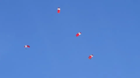Teamwork concept. Group skydivers perform complex acrobatic figures in blue sky Stock Footage 221347305