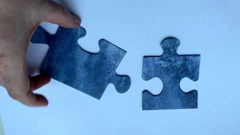 Teamwork concept two pieces of jigsaw puzzle hand connects on blue background Video stock 168255615
