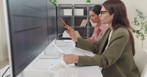 Teamwork on data analysis with businesswomen at computer monitors in office Stockbeeldmateriaal 344348558