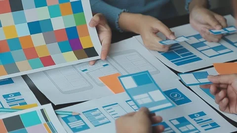 Teamwork develops mobile app ui ux design layout on paper at the office 動画素材 325476921