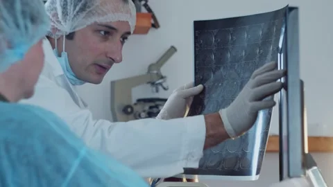 Teamwork of doctors when considering a medical history on an X ray image of a br Stock Footage 172147048