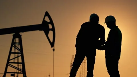 Teamwork to generate energy. Two working engineers are working on an oil pump Stock-Footage 234388839