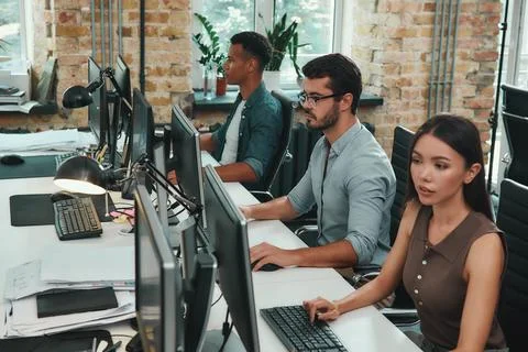 Teamwork . Group of young employees working on computers while sitting in modern 写真素材