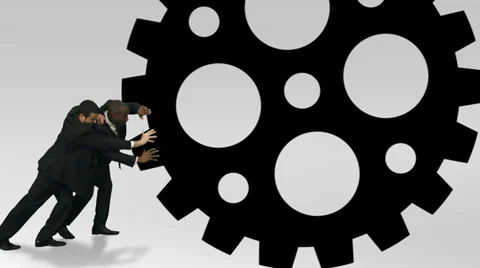 Teamwork helps the cogs turn. Two business men fitting the crucial piece in the 库存影片 32721143