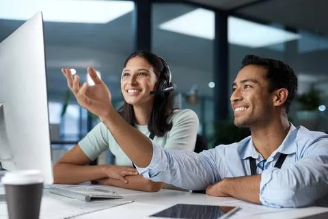 Teamwork makes the call work. Shot of a young man and woman using a computer  Foto stock