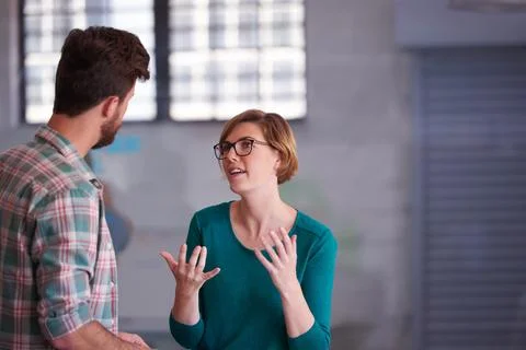Teamwork makes the dream work. a group of young creatives talking around a table Stock Photos