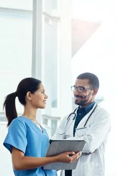 Teamwork makes the hospital work. two young doctors using a digital tablet in a Stock Photos