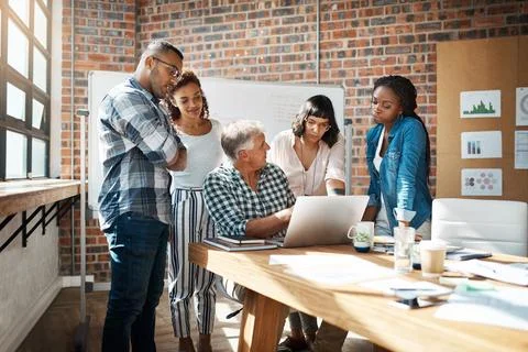 Teamwork makes the task work. a group of colleagues using a laptop together in a Foto stock