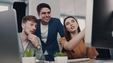 Teamwork in modern office, mans and woman managers look at the computer screen Stock Footage 153608074
