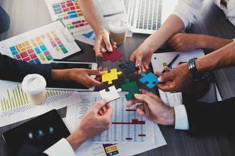 Teamwork of partners. Concept of integration and startup with puzzle pieces Stock Photos