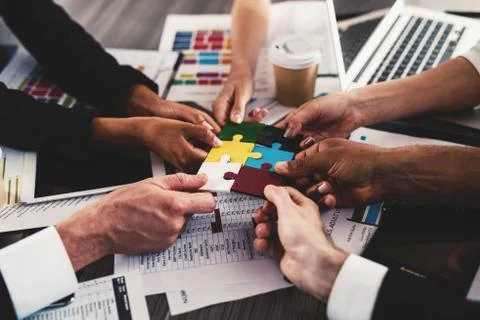 Teamwork of partners. Concept of integration and startup with puzzle pieces Stock Photos