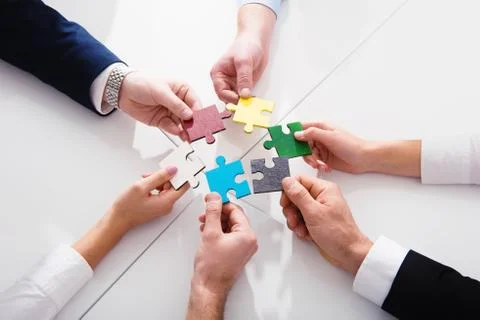 Teamwork of partners. Concept of integration and startup with puzzle pieces Stock Photos