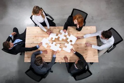 Teamwork of partners. Concept of integration and startup with puzzle pieces Stock Photos