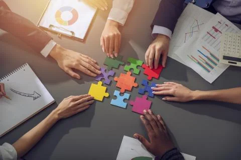 Teamwork of partners. Concept of integration and startup with puzzle pieces Stock Photos