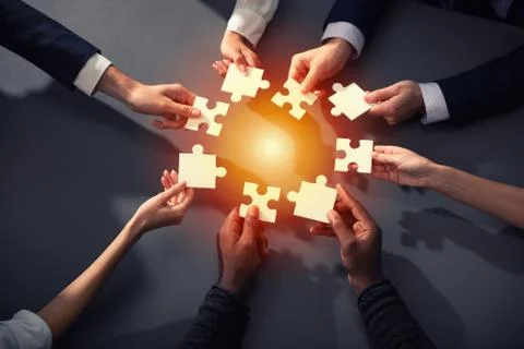 Teamwork of partners. Concept of integration and startup with puzzle pieces Stock Photos