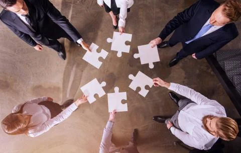 Teamwork of partners. Concept of integration and startup with puzzle pieces Stock Photos