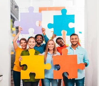 Teamwork of partners that work with puzzle as integration and startup concept Stock Photos