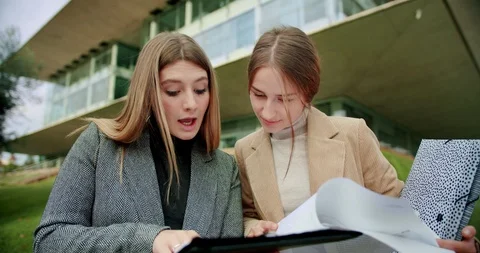 Teamwork portrait of two nice business girls making homework research with Stock Footage 120746496