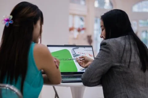 Teamwork presentation, Women collaborating over a laptop, refini Stock Photos