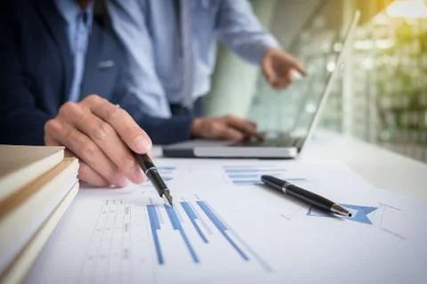 Teamwork process, Businessmen hands pointing at laptop and document during ex Stock Photos